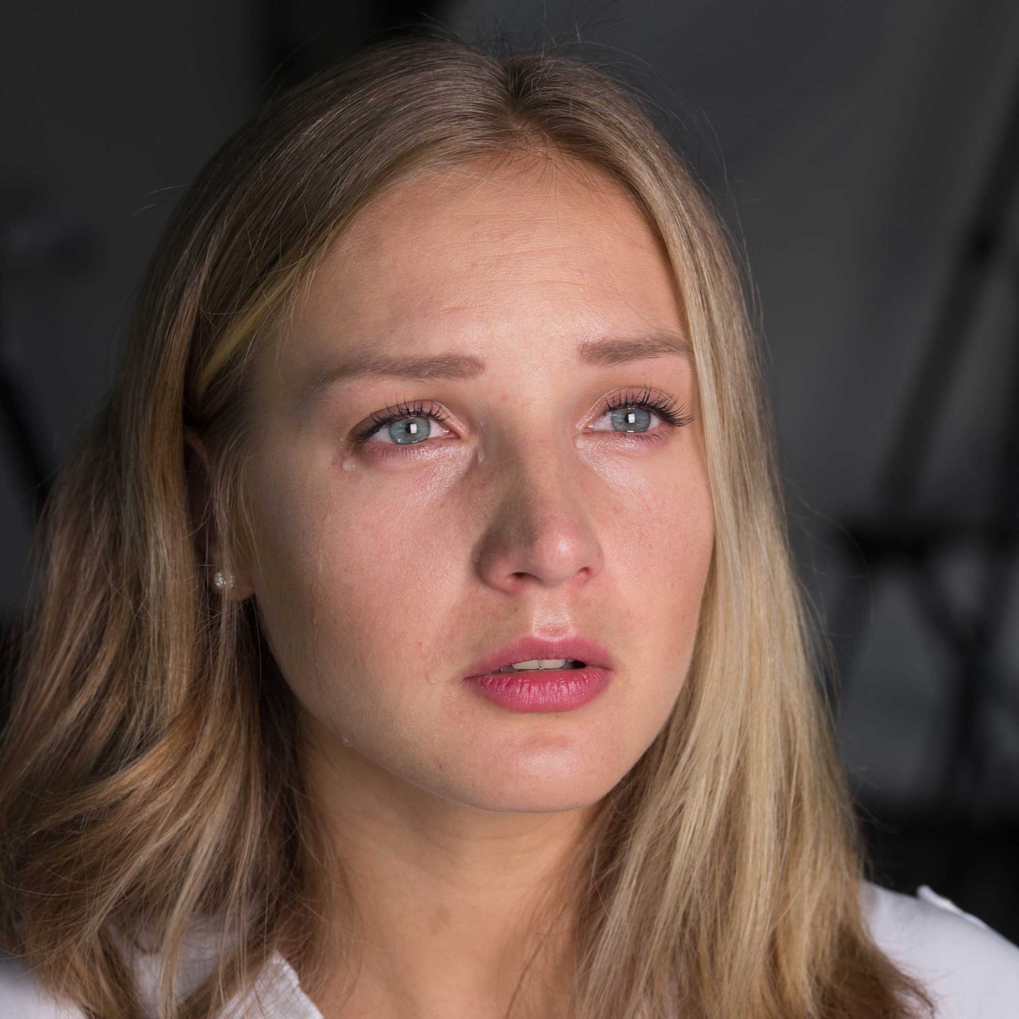 Close-up of woman with watery eyes showing Tear Stick effect