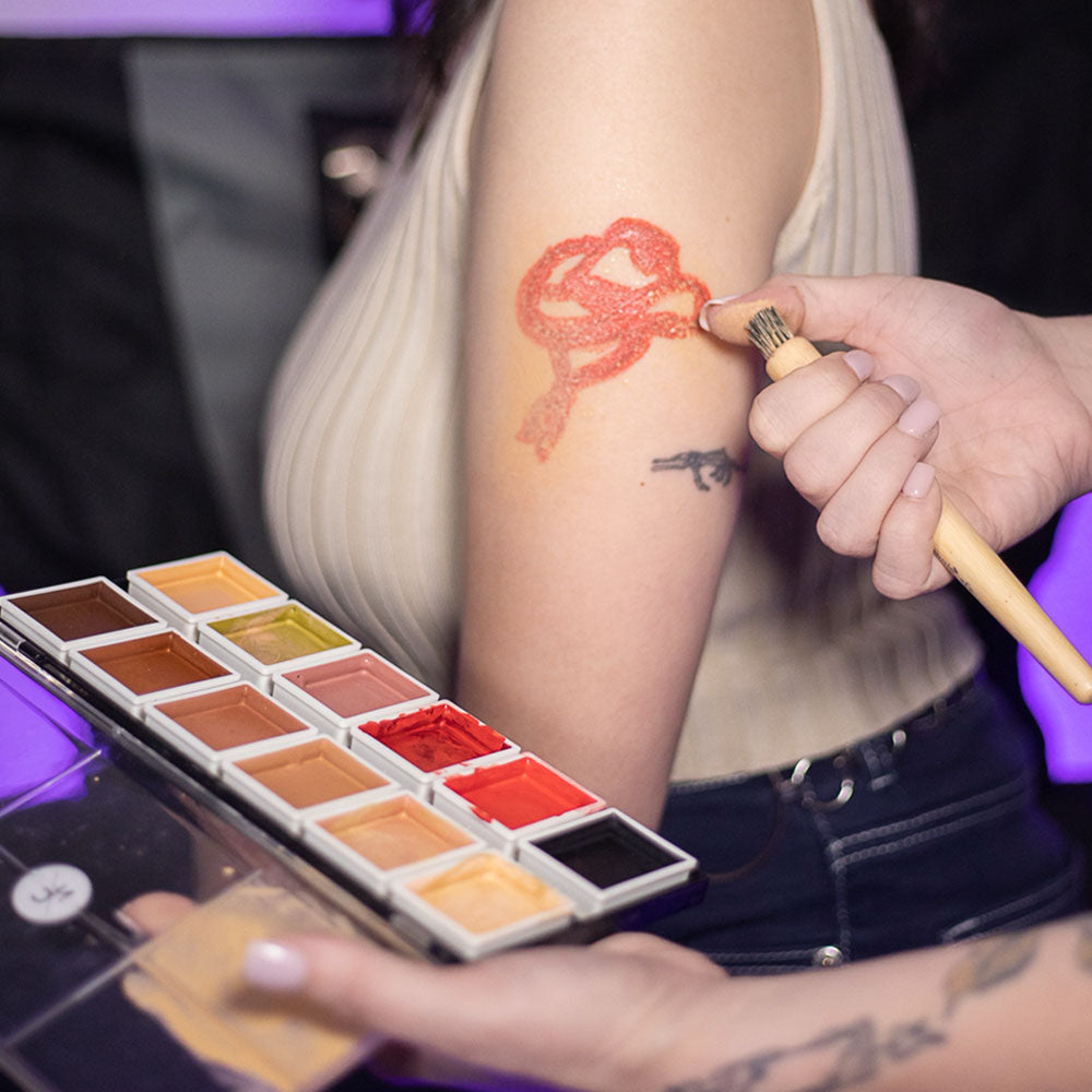 Makeup artist applying 12-Color Tattoo Cover-Up Palette to client&