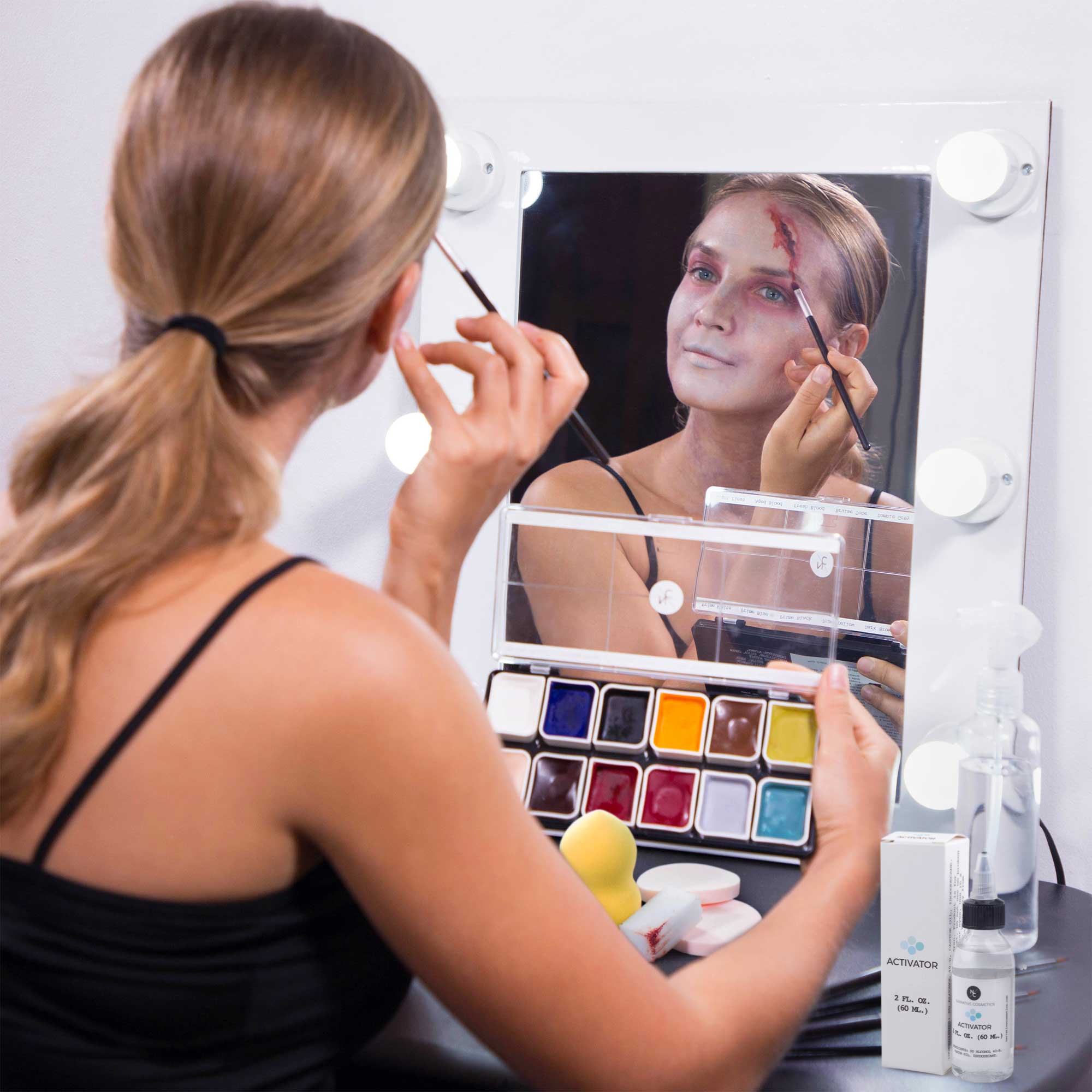Artist applying zombie SFX makeup with alcohol palette